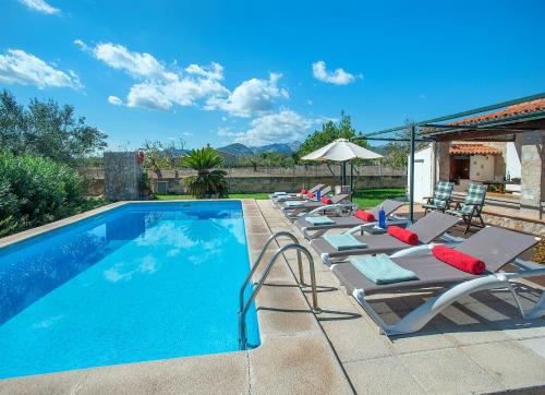 une rangée de chaises longues à côté d'une piscine dans l'établissement Owl Booking Villa Finquita - Rustic Stay, à El Port