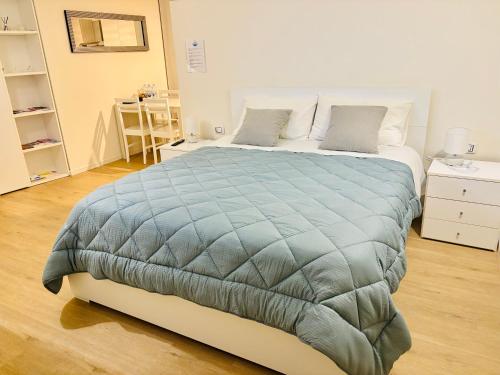 a bedroom with a large bed with a blue comforter at Sky House Sant'Orsola in Bergamo