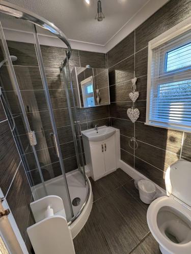 a bathroom with a shower and a toilet at 179, Two bed chalet on Sund0wner Holiday Park - Sleeps 4, free WiFi, sorry no pets - entertainment options close by in Hemsby