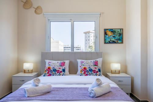 a bedroom with a large bed with pillows and a window at Ondo 2-Bedroom Apartment in Larnaca