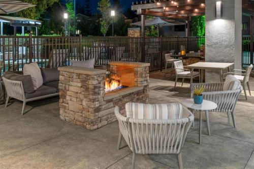 a patio with a fireplace and chairs and tables at Homewood Suites by Hilton Palo Alto in Palo Alto