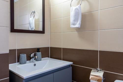 a bathroom with a sink and a mirror at Ondo 2-Bedroom Apartment in Larnaca