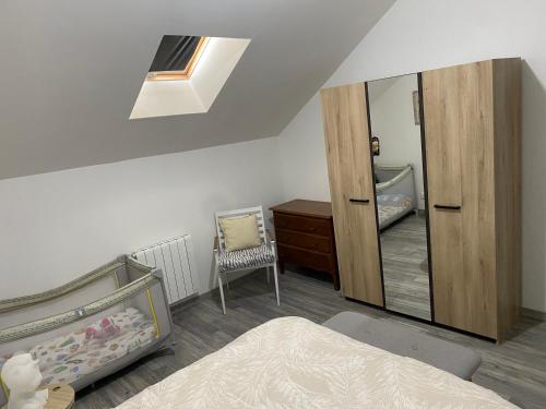 a bedroom with a mirror and a bed and a chair at Le Barbès in Montceau-les-Mines