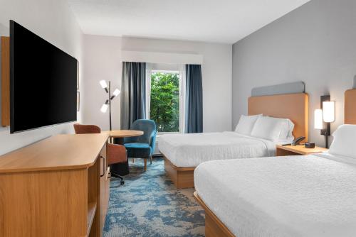 a hotel room with two beds and a flat screen tv at Hampton Inn Gainesville-Haymarket in Gainesville