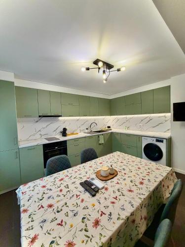 a kitchen with a table and chairs with a table and a tablecloth at Apartament Draganovi 8B in Kazanlŭk