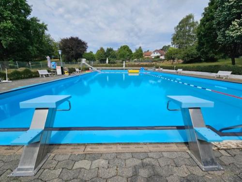 a large swimming pool with blue water at Ferienwohnung Ilkas Inn in Michelstadt