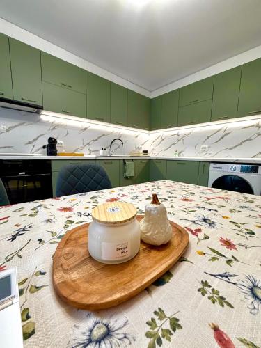 a kitchen with green cabinets and a jar of butter on a table at Apartament Draganovi 8B in Kazanlŭk