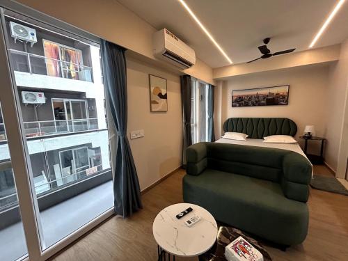 a room with a bed and a couch and a window at UHomes Pune airport in Pune