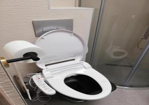 a bathroom with a toilet with a remote control at Attila Beach Boglár in Balatonboglár
