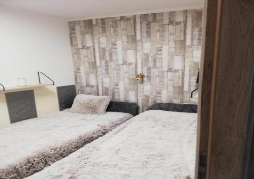 a bedroom with two beds and a wall at Attila Beach Boglár in Balatonboglár