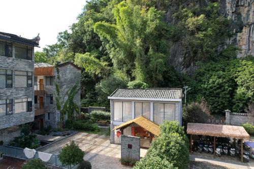 a house with a greenhouse in the middle of a yard at Qingshan Yuandai Boutique Homestay Yangshuo in Yangshuo