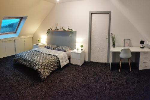 RiedwihrにあるVilla au calme avec piscine et jacuzziのベッドルーム1室(ベッド1台、デスク、デスク付)