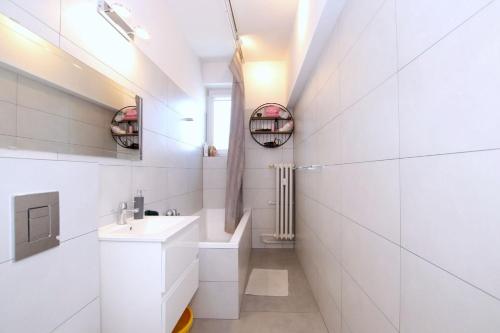 a white bathroom with a sink and a mirror at Perfect Location Apartment with Balcony Oldtown in Gdańsk