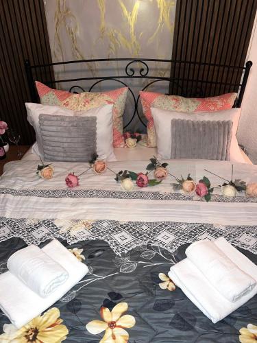 a bed with two pillows and flowers on it at Apartment Jelka 1 lux in Umka