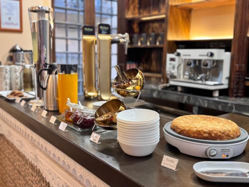 a kitchen counter with plates and utensils on a counter top at Hotel Boutique Casón De Los López in Toledo