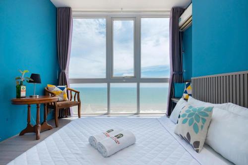 a bedroom with a bed and a large window with the ocean at Oasky Vũng Tàu - Pooh House 5 in Vung Tau