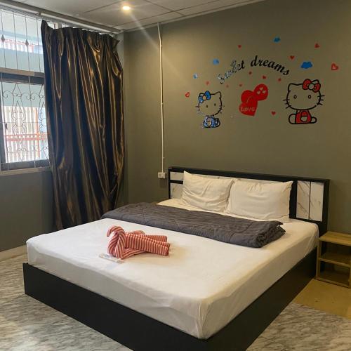 a bedroom with a bed with hello kitty decals on the wall at Saran Hotel krabi Thailand in Krabi