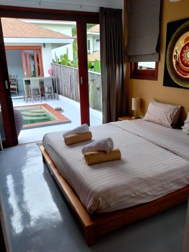 a bedroom with a large bed with two towels on it at VILLA JADE orchid life residence in Koh Samui