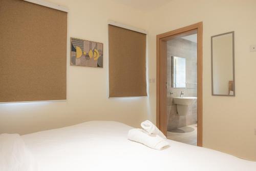a bedroom with a bed and a bathroom with a sink at CasaNova Airport Suites in Accra
