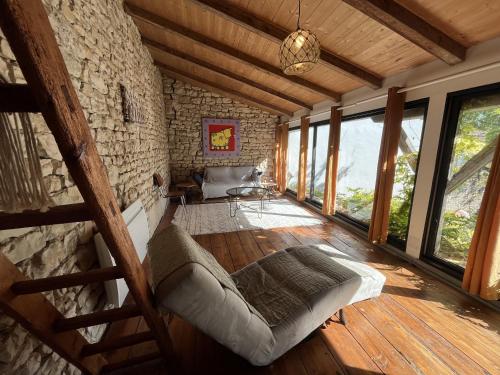 ein Wohnzimmer mit einer Couch und einigen Fenstern in der Unterkunft Maison de la Beureliere in Sainte-Marie-de-Ré