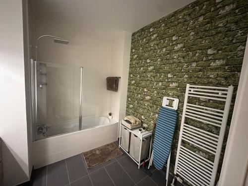 une salle de bain avec douche et un mur en pierre dans l'établissement Le beau Strasbourg, à Strasbourg