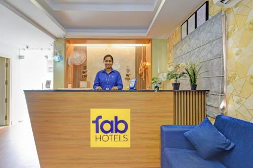 a man standing behind a counter in a hotel lobby at FabHotel Metro - Nr Secunderabad Railway Station in Hyderabad