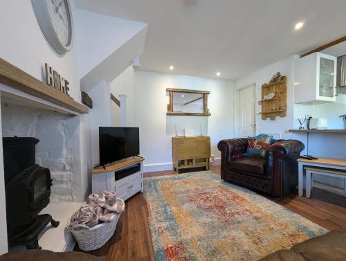 a living room with a couch and a television at Primrose cottage - Upper cwmbran in Pontnewydd