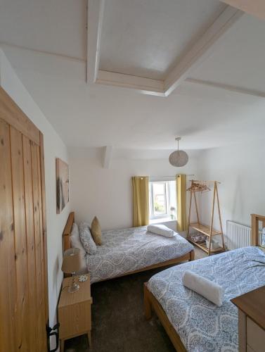 a bedroom with two beds and a window at Primrose cottage - Upper cwmbran in Pontnewydd