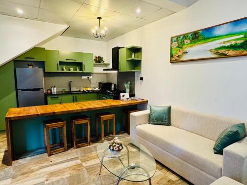 a living room with a couch and a kitchen at The Green Lodge Kandy in Kandy