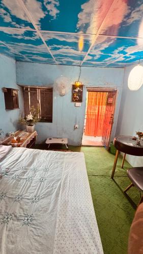 a bedroom with a bed and a painting of clouds on the ceiling at Mantra Mountain Organic Homestay in Pokhara