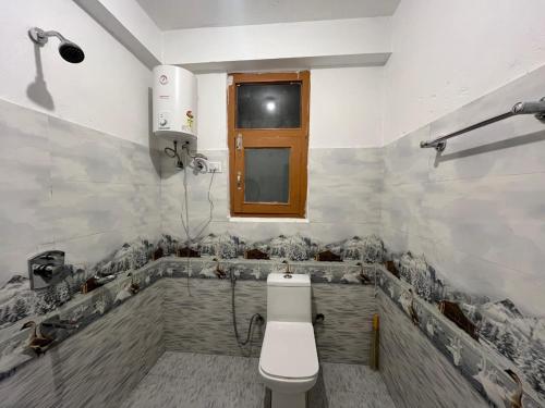 a bathroom with a toilet and a bath tub at Samora Retreats, Manali in Vashisht
