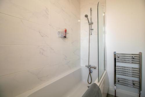 a white bathroom with a shower and a tub at Kingley Court By Greenstay Serviced Accommodation - A Newly Refurbished 2 Bed Flat In Gateshead - Ideal For Contractors - Business Travellers & Relocations - 10 Mins From Newcastle City Centre - Free Parking - Fast Wi-Fi in Gateshead