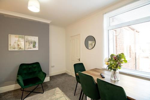 a dining room with a table and green chairs at Kingley Court By Greenstay Serviced Accommodation - A Newly Refurbished 2 Bed Flat In Gateshead - Ideal For Contractors - Business Travellers & Relocations - 10 Mins From Newcastle City Centre - Free Parking - Fast Wi-Fi in Gateshead