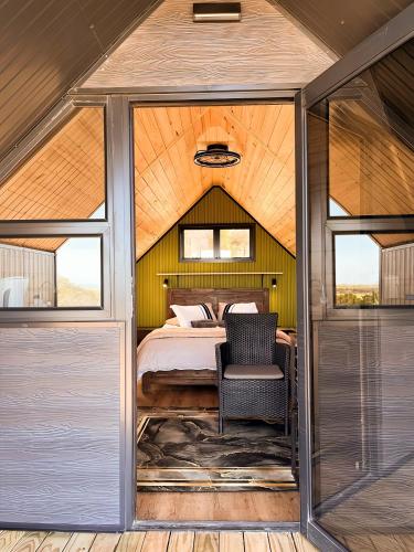 a bedroom in a tent with a bed and a chair at Peace Haven @ Windfarm Accommodation in Yzerfontein