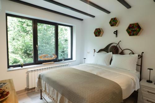 a bedroom with a large bed and two windows at Cabana din padure in Agapia
