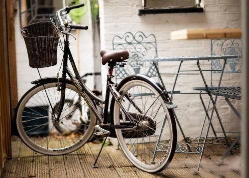 a bike with a basket parked next to a bench at Old Customs House in Harwich