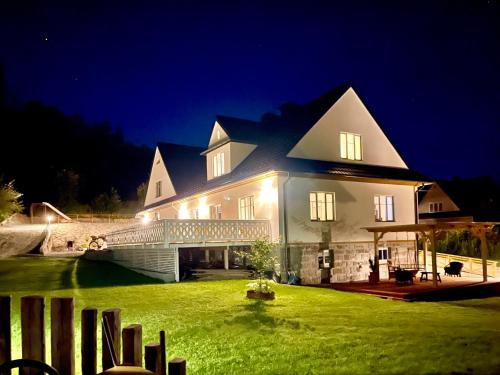 a large house with a green yard at night at Villa Pippi in Tokarnia