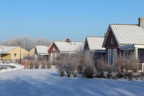 eine Reihe von Häusern mit Schnee auf dem Boden in der Unterkunft Reitcamp Börgerende GmbH & Co. KG in Börgerende-Rethwisch