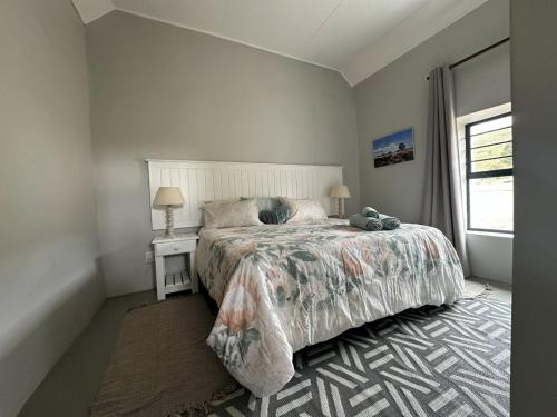 a bedroom with a large bed and a window at The Sheperd's Cottage in Joubertina