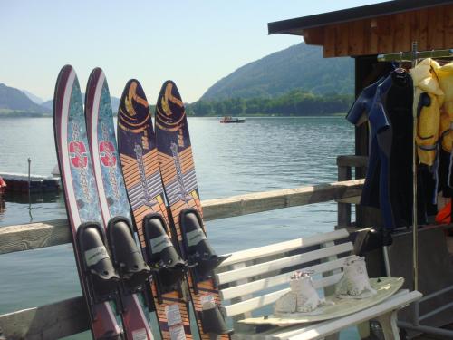 a bunch of skis on a bench next to the water at Ferienwohnungen Steger in Bodensdorf