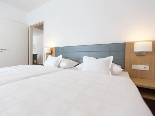 a large white bed in a hotel room at Hotel Seepark Garni in Überlingen