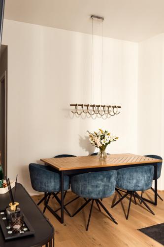 a dining room with a table and blue chairs at Melody Apartments Vienna - Modern & Spacious with Terrace in Vienna