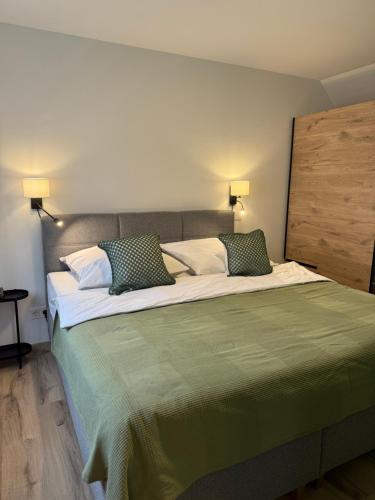 een slaapkamer met een groot bed met twee kussens bij Ferienwohnung in den Mühlgärten in Dahn