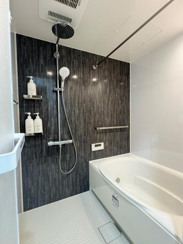 a bathroom with a shower and a bath tub at OmOTeNaShI YAHIRO in Tokyo