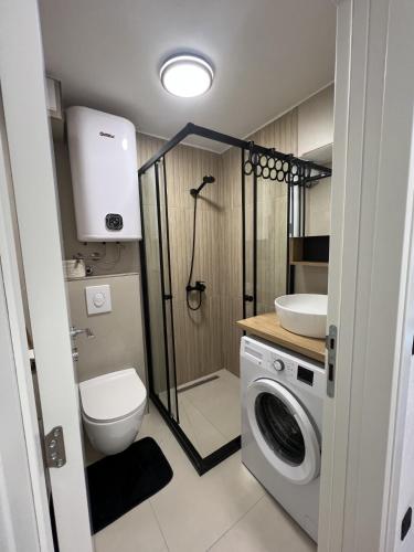 a bathroom with a toilet a sink and a washing machine at Casa Mare in Prčanj