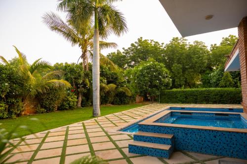 a swimming pool in a yard with a palm tree at Sukoon The घर in Jodhpur
