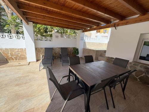 Una mesa y sillas de madera en un patio. en Stella Villa Mojacar, en Mojácar