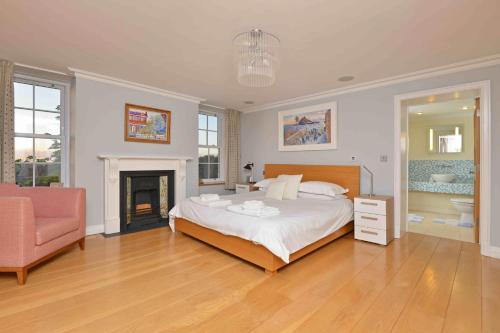 a large bedroom with a bed and a fireplace at Bedford House in Brentor