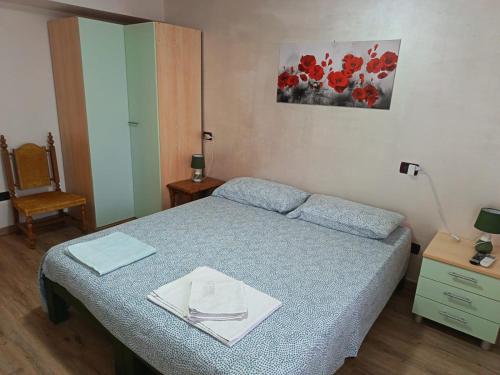 a small bedroom with a bed and a chair at Il Casale del Miele in Fraforeano