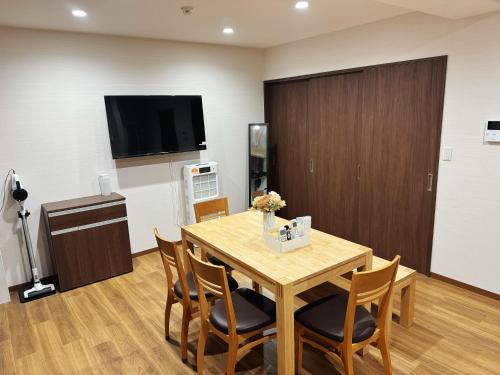 a dining room with a table and chairs and a television at OmOTeNaShI YAHIRO in Tokyo